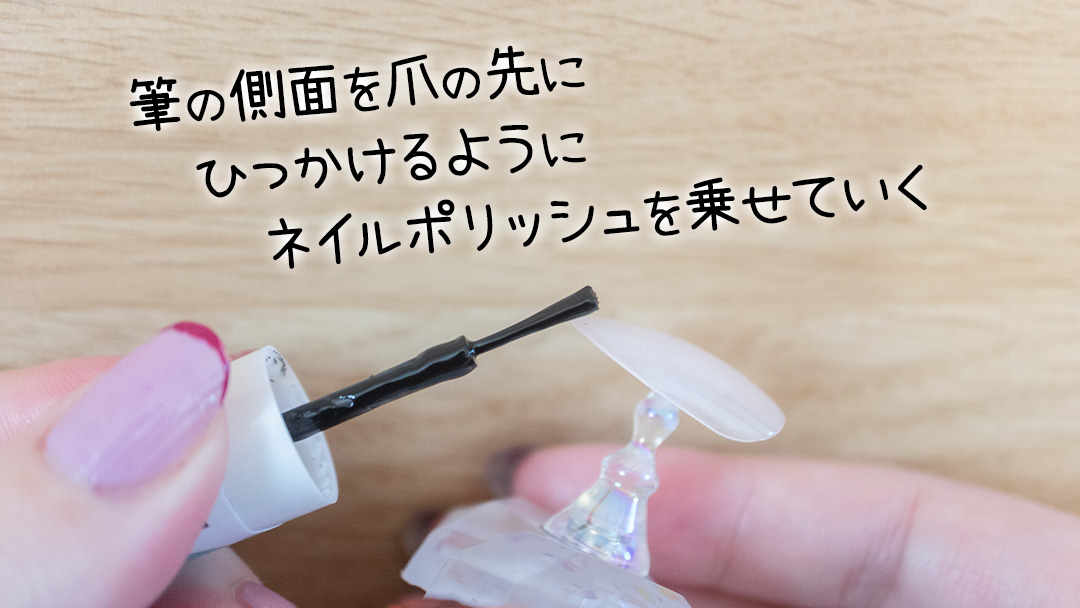 筆の側面を爪の先にひっかけるようにネイルポリッシュを乗せていく